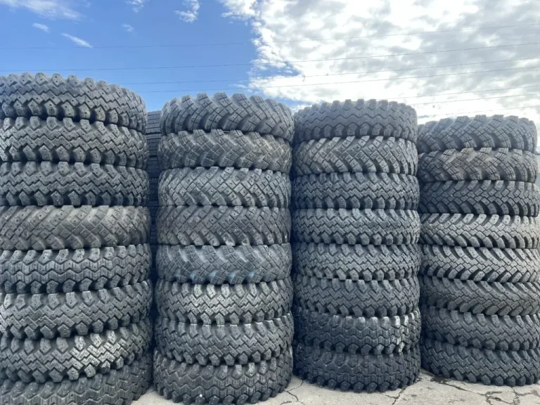 Stacks of used block-pattern truck tyres at the export yard in Japan, May 2026