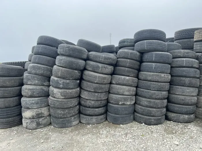 Passenger car tires graded and stacked by size in the yard.